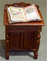 Desk with book which has leather cover and is styled after actual books from Tudor era.